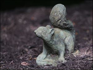 A squirrel statue sits in the landscaped yard.