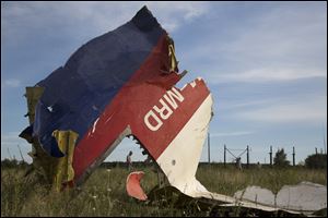 A man walks past a piece of the crashed Malaysia Airlines Flight 17 near the village of Hrabove, eastern Ukraine Monday.