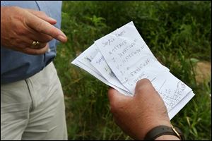 Handwritten payment slips, delivered to migrant workers, are examined during a tour of a migrant laborer camp on Sunday outside Raleigh, N.C. Many of the workers who tend and harvest tobacco crops are undocumented and unseen. 