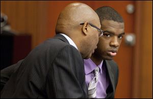 Assistant Washtenaw County Public Defender Lorne Brown, left, talks to his client, Ed Thomas during Thomas' trial.