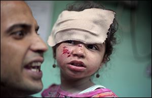 A Palestinian man carries a wounded girl at the Kamal Adwan hospital in Beit Lahiya after receiving treatment for her wounds caused by an Israeli strike at a U.N. school in Jebaliya refugee camp.