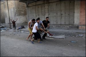 Palestinians rush an injured man following an Israeli Strike in Shijaiyah neighborhood, eastern Gaza City today.