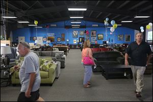 Visitors take a look around inside one of the show rooms at the new Appliance Center Outlet in Maumee.