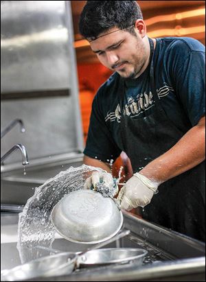 Antonio Vasquez cleans dishes at El Vaquero at The Docks. After the water advisory was lifted, the restaurant cleaned dishes and replaced any tainted ice with clean ice.