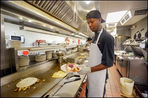 Chef T.J. Harvey, a worker at the Original Pancake House, puts the finishing touches on crepes during the lunch rush on Monday. The restaurant was closed both Saturday and Sunday. ‘‍We were probably in the thousands of dollars lost. It was pretty bad,’ said Candie Hayes, the restaurant’s manager.