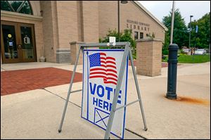 A sign in front of the Bedford Branch Library identifies it as a polling station for the Michigan primary Tuesday.