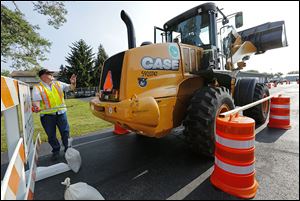 Tom Richcreek, facilities manager, measures how close a front end loader came to a street sign during the District Two Annual Roadeo.