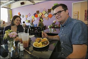 Madeline Harts of Bowling Green and Collin Stegeman of Toledo eat on Thursday at Pam’s Corner in downtown Toledo.     