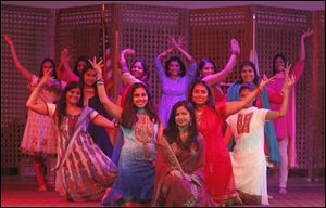 Sneha Shah, center, and other cast members from a dance number rehearse for 