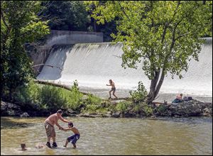 People play in the water near the Ballville Dam on the Sandusky River. Some worry that the plan to dismantle the dam will allow all of the trapped sediment to flow into Lake Erie, possibly worsening algal blooms.