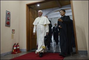 Pope Francis, left, arrives to attend a meeting with Asian bishops Sunday at the Haemi Martyrs Shrine in Haemi, south of Seoul.