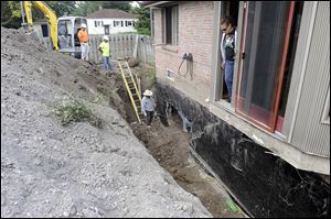 Gretchen Domino stands in a doorway at her home where water flooded her basement and become so deep that it blew out a part of the basement wall. Floods ravaged the Detroit suburb following record rainfall on Aug. 12.