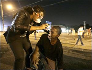 A man is helped ease the effects of tear gas during a protest Monday.