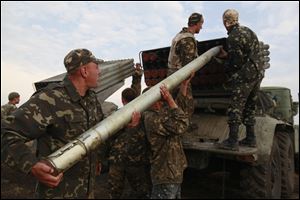 Ukrainian soldiers load a Grad missile during fighting with pro-Russian separatists close to Luhansk, eastern Ukraine, Monday.