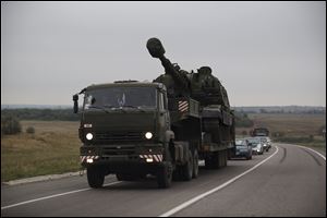 A Russian military truck carries a MSTA-S self-propelled howitzer about 10 kilometers from the Russia-Ukrainian border control point at Donetsk.