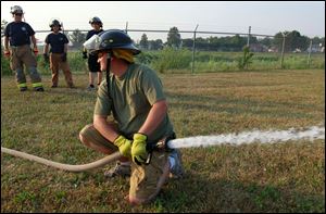 Waterville volunteer firefighter John Cannon purges air from a fire hose during weekly training.