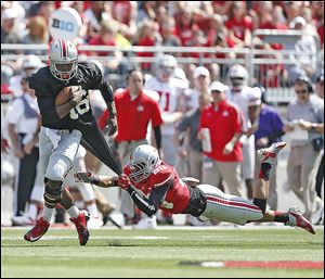 J.T. Barrett tries to get past Ron Tanner in Ohio State’s spring game. Barrett will take his first snaps against Navy on Saturday.