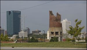 A portion of the last smokestack at the Toledo Edison Power Plant in East Toledo is imploded Friday.