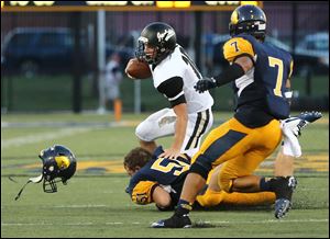 Perrysburg QB Gus Dimmerling (10) runs over Whitmer LB Mike Rickard (51) during a football game Friday, August 29, 2014 at Whitmer High School.