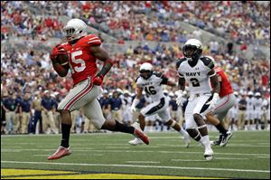 Ohio State running back Ezekiel Elliott, left, runs past Navy safety Parrish Gaines (2) and linebacker Chris Johnson (46) for a touchdown.