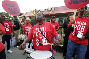 Carmalita Johnson drums as protesters participate in a rally outside a McDonald’s on Chicago's south side today as labor organizers escalate their campaign to unionize the industry's workers.