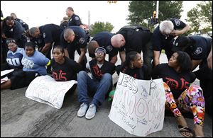 Police handcuff protesters blocking traffic on Mack Avenue in Detroit.