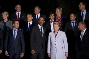 President Obama, front row center, stands with NATO heads of state and government including Lithuanian President Dalia Grybauskaite, front row center right, and NATO Secretary General Anders Fogh Rasmussen, front left, as they pose for a group photo prior to a NATO summit dinner at Cardiff Castle in Cardiff, Wales on Thursday.