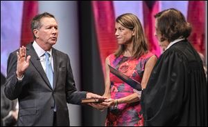 Ohio Supreme Court Chief Justice Maureen O’Connor swears in Gov. John Kasich for his second term as his wife, Karen, holds a Bible during the ceremonial swearing-in.