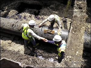 Technicians work on an Enbridge pipeline near Fredonia Township, Mich., in August, 2010.