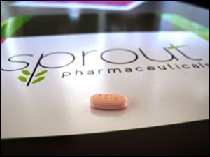 A tablet of flibanserin sits on a brochure for Sprout Pharmaceuticals in the company's Raleigh, N.C., headquarters.