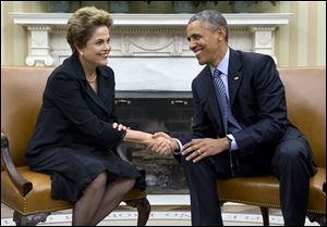 President Obama shakes hands with Brazilian President Dilma Rousseff in the Oval Office of the White House in Washington, today.