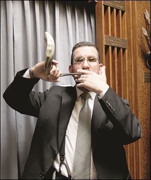 Rabbi Evan Rubin of Congregation Etz Chayim in Toledo demonstrates a shofar made from a goat’s horn.