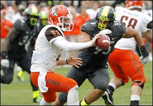 Bowling Green quarterback Matt Johnson (11) takes a shuffle pass ahead of the hit from Purdue's Evan Panfil.