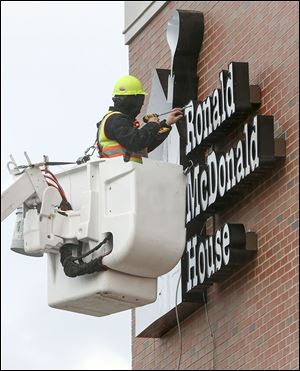 A worker puts the finishing touches on the sign for the new Ronald McDonald House in West Toledo. The new house is  in front of the ProMedica Toledo Children’s Hospital.