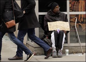 A man panhandles on the street Jan. 25 in Chicago. A lawsuit brought by panhandlers who say they lose up to $10 a day because authorities bar them from a popular public square in Chicago is set to go to trial. 