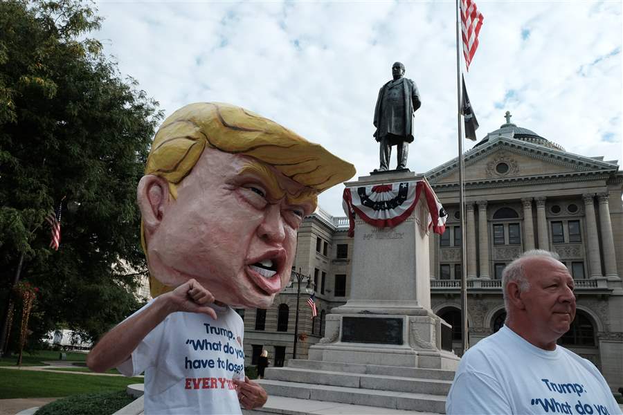 Man in giant paper-mache Trump head touring downtown Toledo streets ...