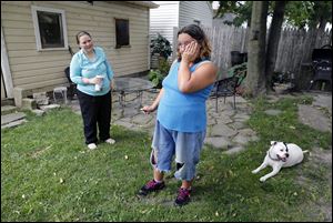 An emotional Diann Wears pauses for a moment as she and her dog, Cow, speak with her new landlord, Theresa Kim, who offered them the place to stay with low rent and no deposit.