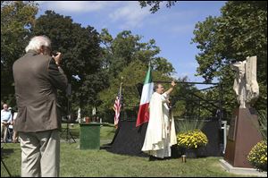 Father Enzo Addari blesses the sculpture unveiled during the Italian-American memorial service held to commemorate the wreck of the Wabash at Oakwood Cemetery in Adrian. The sculpture marks the burial site of five of the victims.