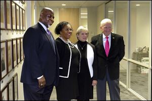 Former Toledo mayor Mike Bell, left, current Mayor Paula Hicks-Hudson, and former mayors Donna Owens and Carty Finkbeiner pose in front of the ‘Portraits of Toledo Mayors.’