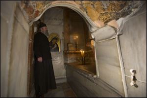 A Greek priest stands inside the renovated Edicule in the Church of the Holy Sepulchre.