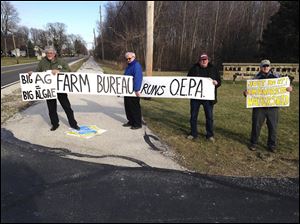 Members of Advocates for a Clean Lake Erie protest outside the University of Toledo’s Lake Erie Center.