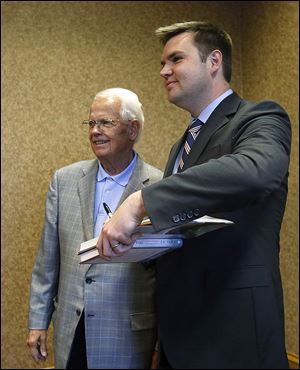 ‘Hillbilly Elegy’ author J.D. Vance, right, signs his book for Harvey Tolson during the 2017 Lucas County Lincoln Day Dinner at the Pinnacle in Maumee on Monday.