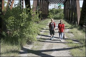 Michelle Querback of South Toledo and her grandson, Christopher Lanting, walk across the Sumner Street bridge over Norfolk Southern railroad tracks.