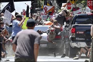 People fly into the air as a vehicle drives into a group of protesters demonstrating against a white nationalist rally in Charlottesville, Va., in August. South Toledo man James Alex Fields, Jr., was charged with five additional felonies today for allegedly hitting protester Heather Heyer with the car, killing her.