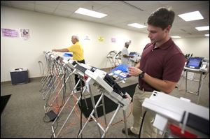 Luke Powell loads memory cards into machines for counting at the Lucas County Board of Elections in Toledo on Sept. 12, 2017.