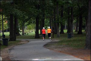 Two walkers make their way down the trail in Olander Park on Oct. 5. The parks system seeks a 0.8 mill property tex levy.