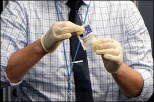 A representative of the Lucas County Public Health Department holds a dust wipe that is used to get an accurate assessment of lead particulate in a house. Opponents of the city's lead safe ordinance seek to roll back one of its most important elements.