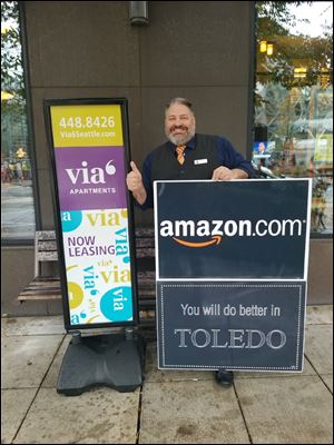 Michael Taylor, a Toledo native, has hung a message for Amazon in his window across the street from the online retail giant's headquarters in Seattle.