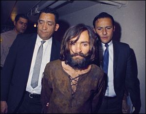 Charles Manson being escorted to his arraignment on conspiracy-murder charges in connection with the Sharon Tate murder case in 1969. Manson, who was serving 9 life sentences in prison, died Sunday at the age of 83.