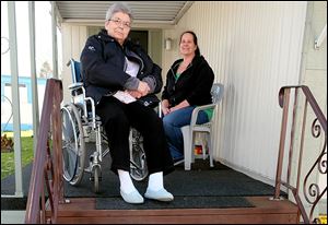 Toledoan Karen Ryan, left, needs help from her daughter, Kim Castillo, to get down the steps of her Reynolds Senior Village home on S. Reynolds Rd. The Area Office on Aging will use a $25,000 grant from Fifth Third Bank Foundation to make needed improvements to several area seniors' homes, including a new lift to help her navigate those steps.  